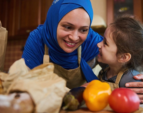 Couple holding paper bag with grocery from supermarket in kitche